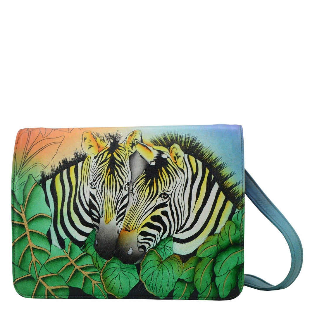 Anna by Anuschka style 8301, handpainted Medium Saddle Crossbody. Zebra Safari painting in multi color. Featuring magnetic flap entry to three open compartments and two zippered compartments.
