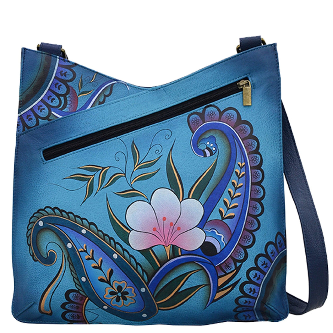 Anna by Anuschka style 8312, handpainted V Top Large Crossbody. Denim Paisley Floral painting in blue color. Featuring magnetic snap button entry to main compartment, Fits E-Reader, Fits tablet, Fits Laptop.