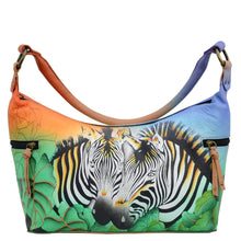 Load image into Gallery viewer, Anna by Anuschka style 8320, handpainted Medium East West Hobo. Zebra Safari painting in multi color. Featuring inside zippered wall pocket, two multipurpose pockets and two zippered side pockets.
