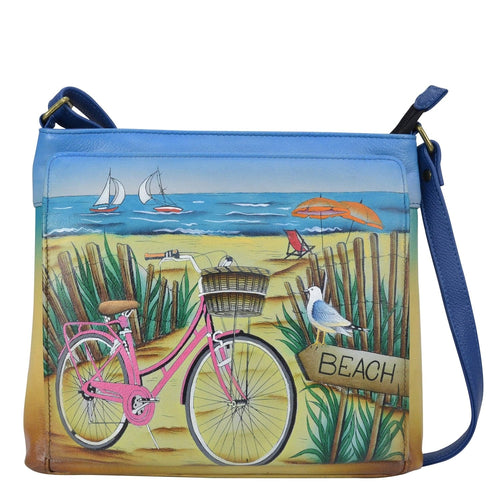 Anna by Anuschka style 8437, handpainted Crossbody Organizer. Beach Day painted in Blue color. Featuring inside zippered wall pocket, slip pocket and two multipurpose open gusseted pockets with crossbody  adjustable strap.